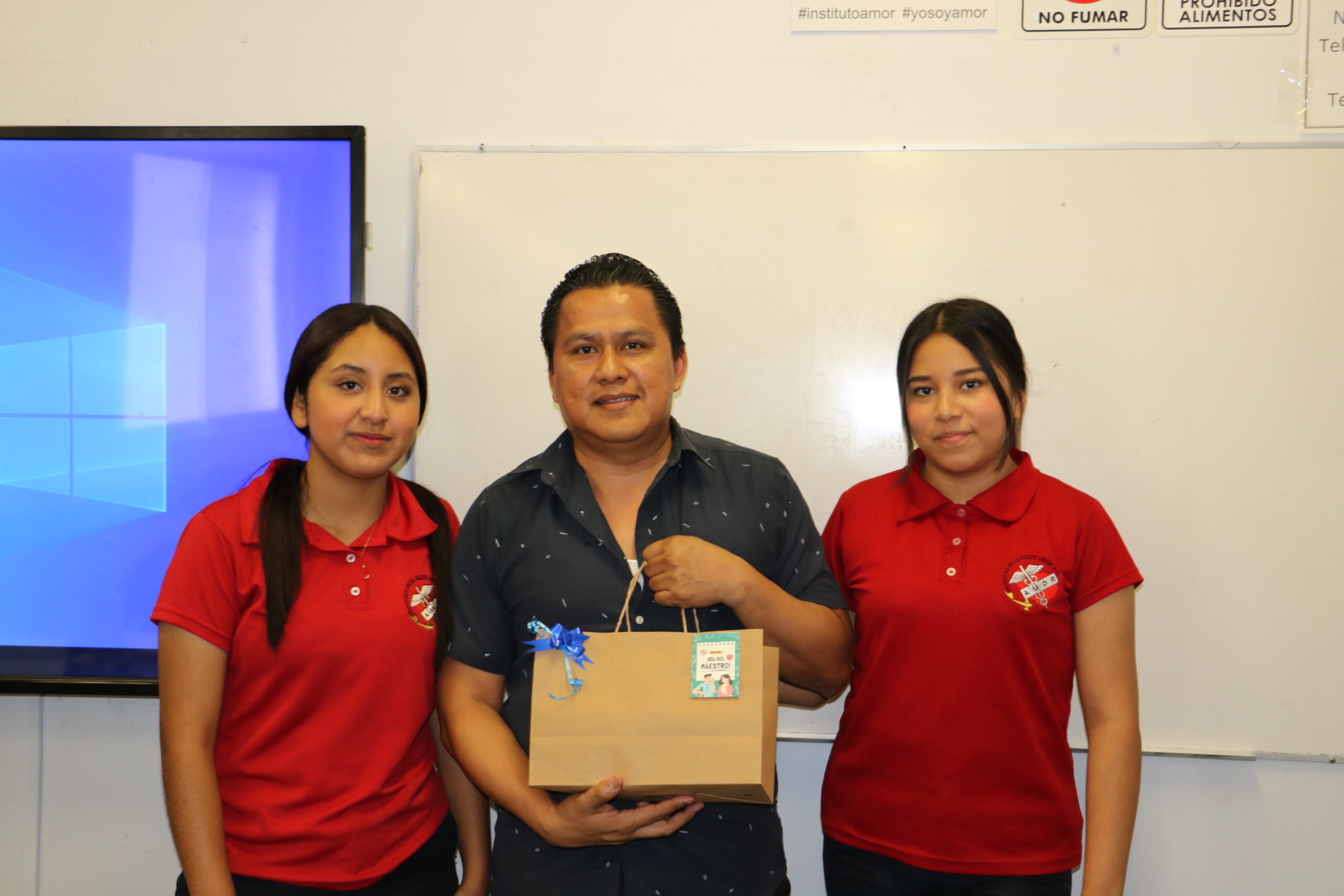 Alumnas del programa académico de enfermería del Instituto en Monterrey entregando obsequio a su maestro durante la celebración del día del maestro