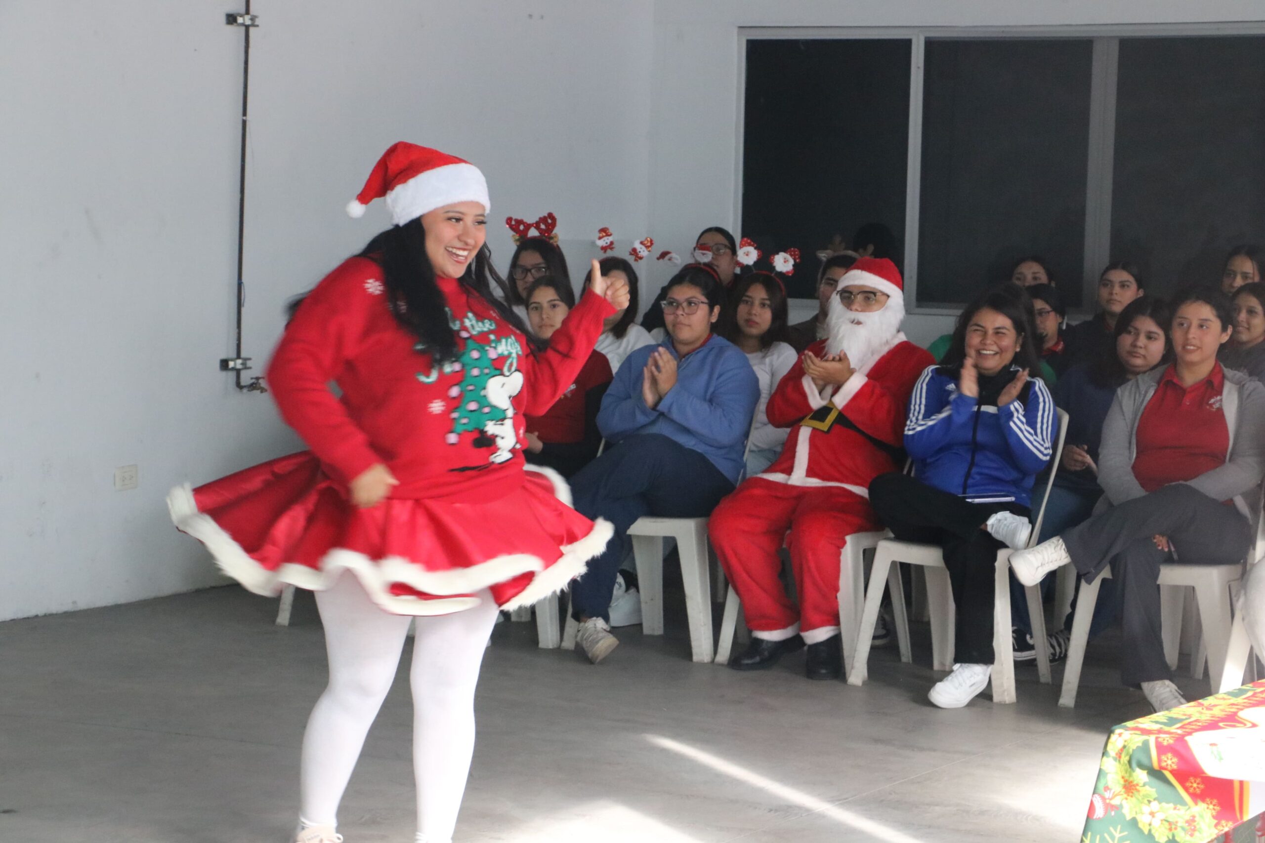 Una chica de bachillerato mostrando su suéter en concurso del festival navideño
